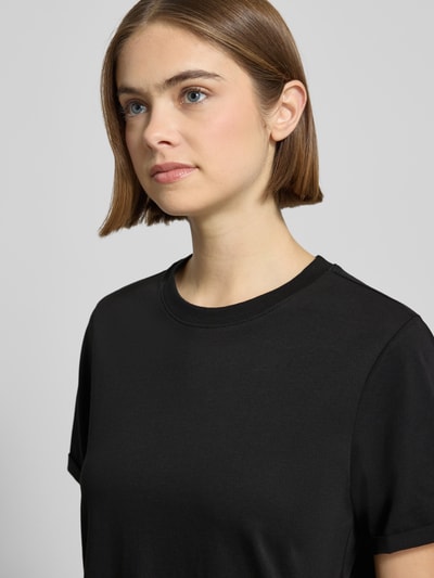 Frauenmodel trägt Regular Fit T-Shirt aus reiner Baumwolle Modell 'RIA' von Pieces in Optik: Unifarben mit Feinripp-Textur, Nahaufnahme Oberkörper.