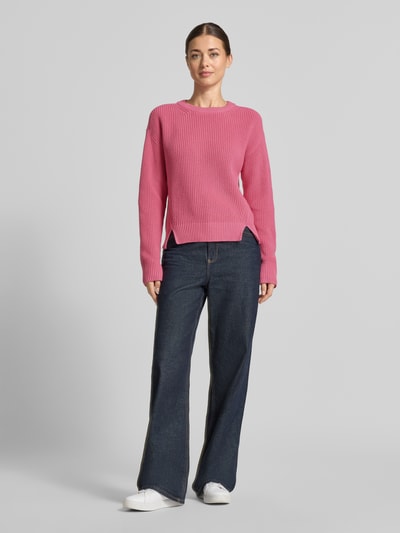 Frauenmodel trägt Slim Fit Pullover aus reiner Baumwolle von Jake*s Casual in Pink mit Rippstruktur, kombiniert mit blauer Jeans, Ganzkörperansicht von vorne.