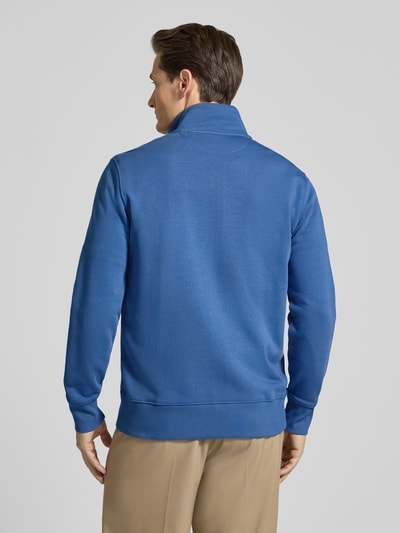 Männermodel trägt Regular Fit Sweatjacke mit Stehkragen Modell 'Gield' von Gant, einfarbig blau, bawełniany mix, krój regular fit, elastische Abschlüsse, ganzkörperansicht rückansicht.