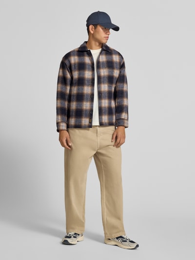 Männermodel trägt Regular Fit Hemdjacke mit Brusttasche Modell 'SOHO OLLIE' von JACK & JONES, kariertes Muster, Ganzkörperansicht von vorne.