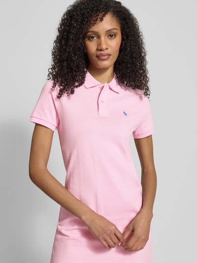 Frauenmodel trägt Regular Fit Minikleid mit Logo-Stitching Modell 'Polo' von Polo Ralph Lauren in zartem Rosa, reine Baumwolle, Polokragen, elastische Ärmelabschlüsse, Nahaufnahme Oberkörper.