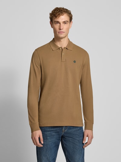 Mannenmodel draagt Regular Fit poloshirt uit puur katoen van MCNEAL in effen bruin met labelstitching, knoopsluiting, met lange mouwen, ruglengte maat M 73 cm, full body vooraanzicht.