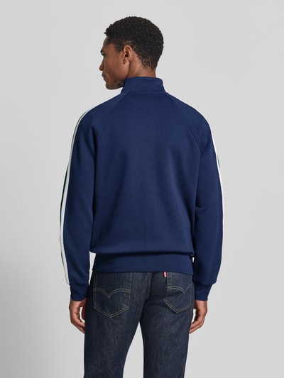 Männermodel trägt Regular Fit Sweatjacke aus Baumwoll-Mix von Polo Ralph Lauren in Dunkelblau mit weißen Streifen, Ganzkörperansicht Rückansicht. Herren Sweatjacke.