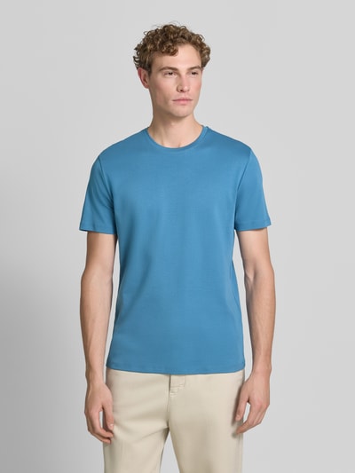 Męski model nosi T-Shirt aus Baumwolle mit Rundhalsausschnitt von Christian Berg Men, krój regular fit, bawełna, okrągły dekolt, długość tyłu w rozmiarze M: 35 cm. Ganzkörperansicht z przodu.