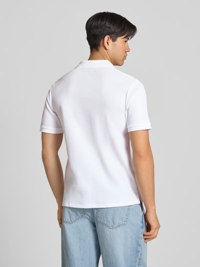 Męski model nosi Regular Fit koszulkę polo z fakturowanym wzorem model 'AUSTIN' od Jack & Jones, mieszanka bawełny, haft, listwa guzikowa, długość tyłu w rozmiarze M: 69 cm, widok całej sylwetki z tyłu
