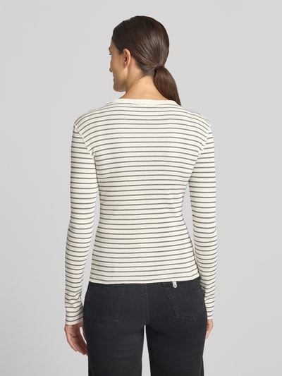 Frauenmodel trägt Slim Fit Longsleeve aus reiner Baumwolle Modell 'NURIT' von DRYKORN, schmale Streifen, Rundhalsausschnitt, Ganzkörperansicht Rückansicht.