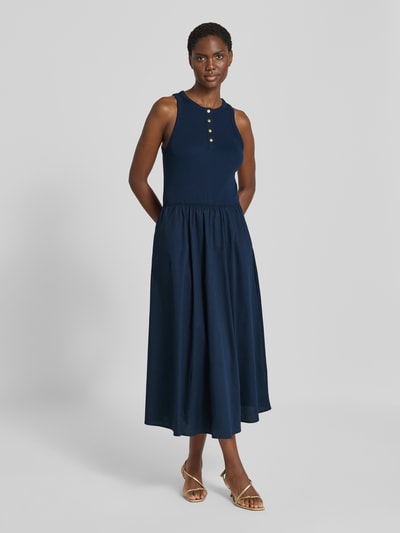 Frauenmodel trägt A-Linie Freizeitkleid aus reiner Baumwolle von Tommy Hilfiger in Dunkelblau, fließender Stoff, Ganzkörperansicht von vorne.