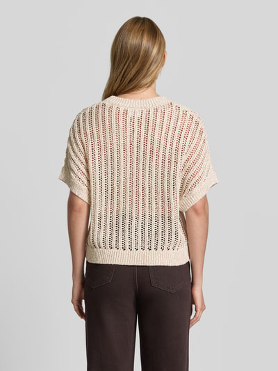 Frauenmodel trägt Strickpullover mit 1/2-Arm und Rundhalsausschnitt von comma, cremefarben, lockere Textur, Ganzkörperansicht Rückansicht.