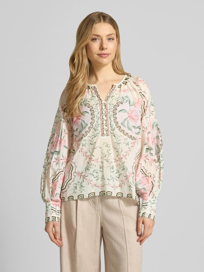 Frauenmodel trägt Relaxed Fit Bluse mit Tunika-Ausschnitt Modell 'Wylde' von MOS MOSH aus reiner Baumwolle mit floralem Allover-Print, Langärmelig, Cremefarben und Rosa, Rückenlänge 59 cm, Ärmellänge 65 cm, Ganzkörperansicht von vorne.
