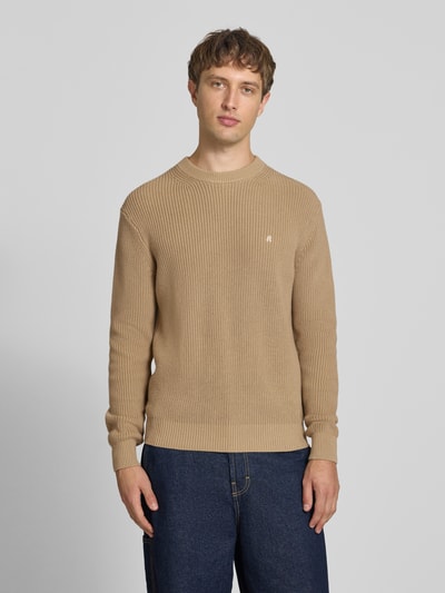 Männermodel trägt Slim Fit Pullover aus reiner Baumwolle in Strick-Optik von Replay in Beige, sichtbares Logo-Stitching, Ganzkörperansicht von vorne