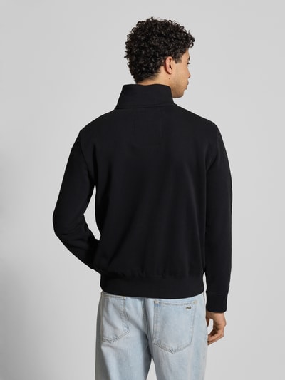 Männermodel trägt Regular Fit Sweatshirt mit Logo-Stitching von Superdry aus schwarzem Baumwoll-Mix, Rückenlänge 65 cm, Ganzkörperansicht Rückansicht.