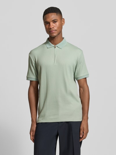 Męski model nosi Regular Fit Poloshirt mit Baumwoll-Anteil Modell 'FAVE' von SELECTED HOMME, efekt: jednolity kolor, krój regular fit, kołnierzyk polo, zapięcie: krótki zamek błyskawiczny, rękaw: krótki rękaw, zakończenia rękawów: prążkowane ściągacze, wykończenie materiału: prążkowany design, całkowity widok z przodu.