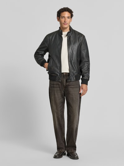 Männermodel trägt Regular Fit Jeans aus reiner Baumwolle Modell 'RAWDY' von DRYKORN in dunklem Braun, 5-Pocket-Design, Ganzkörperansicht von vorne.