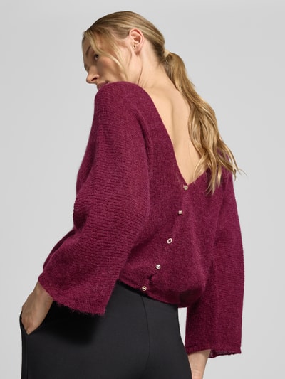 Frauenmodel trägt Relaxed Fit Cardigan mit Mohair-Alpaka-Anteil Modell 'Isaac' von ba&sh, weinrot, Strick-Optik, 3/4-Arm, Knopfleiste, Rückenansicht, Nahaufnahme Oberkörper, Damen Cardigan, Material-Mix