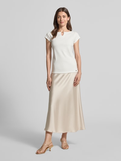 Modelka nosi T-Shirt mit Cut Out od Marc Cain w kolorze białym, prosty krój, modal z domieszką stretchu, dekolt okrągły, cienki prążek, widoczny wycięcie, długość pleców w rozmiarze 36: 56 cm; widok całej sylwetki z przodu.