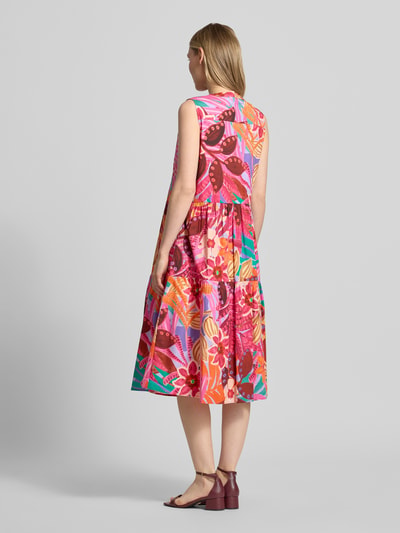 Modelka nosi sukienka midi 'Midikleid im Stufen-Look' od Milano Italy z mieszanki bawełny, efekt stopniowania, taliowany krój, dekolt serafino, długość tyłu 110 cm, szerokość w rozmiarze 36: 47 cm, wielokolorowe wzory, wyraźne tekstury, całość w żywych odcieniach, widok całej sylwetki z tyłu.