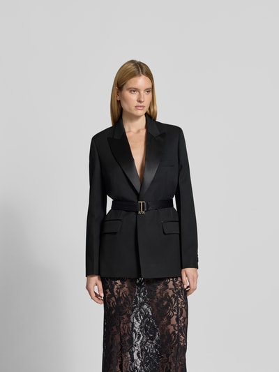 Frauenmodel trägt Blazer mit Schurwoll-Anteil von Victoria Beckham in Schwarz, taillierte Passform, Reverskragen, Taillenband, Nahaufnahme Oberkörper.