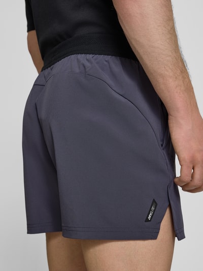 Männermodel trägt Regular Fit Shorts mit Logo-Print von PUMA PERFORMANCE in Grau, elastischer Bund, Eingrifftaschen, Nahaufnahme Rückansicht.