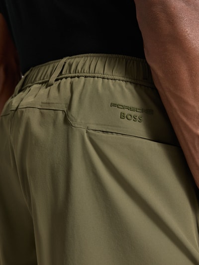 Männermodel trägt Relaxed Fit Bermudas mit Label-Schriftzug Modell 'PS Spirit 70' von BOSS Green X PORSCHE, Detailaufnahme Rückansicht
