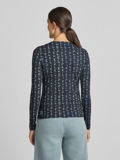 Frauenmodel trägt Longsleeve mit Label-Print von Marc Cain in Dunkelblau mit geometrischem Muster, Material-Mix, Rückenlänge 56 cm, Ganzkörperansicht Rückansicht