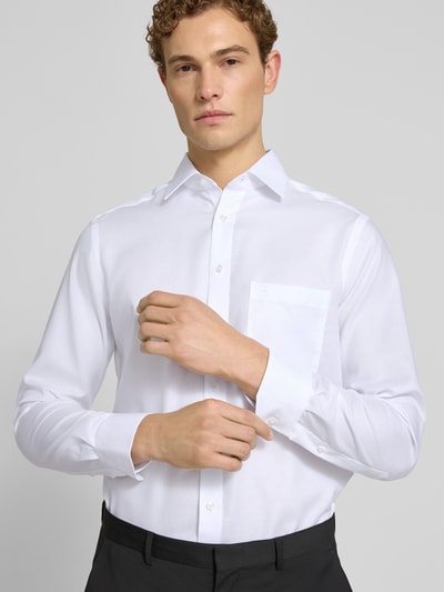 Männermodel trägt Modern Fit Business-Hemd aus Baumwolle mit Kentkragen von OLYMP in Weiß, feine Struktur, Knopfleiste, Nahaufnahme Oberkörper, Reine Baumwolle, Rückenlänge bei Größe 40: 80 cm, Schulterbreite bei Größe 40: 43 cm, Ärmellänge bei Größe 40: 64 cm.