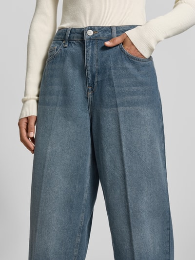 Frauenmodel trägt Baggy Fit Jeans im 5-Pocket-Design von MYON, reine Baumwolle, blauer Denim, Knopf- und Reißverschluss, Nahaufnahme Oberkörper.
