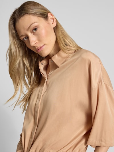 Kobiece modelka nosi Relaxed Fit Bluzkę z mieszanki modalu model 'Lainay' od Drykorn, jasnobeżowy kolor, półrękaw, tunel w talii, półzbliżenie górnej części ciała.