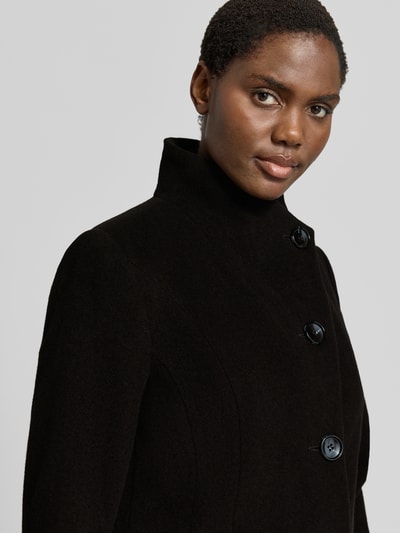 Vrouwenmodel draagt Regular fit lange jas van Milo Coats met scheerwol, opstaande kraag, knoopsluiting, steekzakken, model 'NADA', nahaufnahme bovenlichaam.