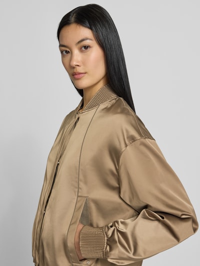 Frauenmodel trägt Regular Fit Blouson mit Leistentaschen Modell 'Petticali' von BOSS in glänzendem Hellbraun, Damen Bomberjacke, Nahaufnahme Oberkörper.