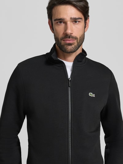 Männermodel trägt Regular Fit Sweatjacke aus Baumwoll-Mix von Lacoste, Optik: Unifarben, Label-Patch, Reißverschluss, Nahaufnahme Oberkörper.