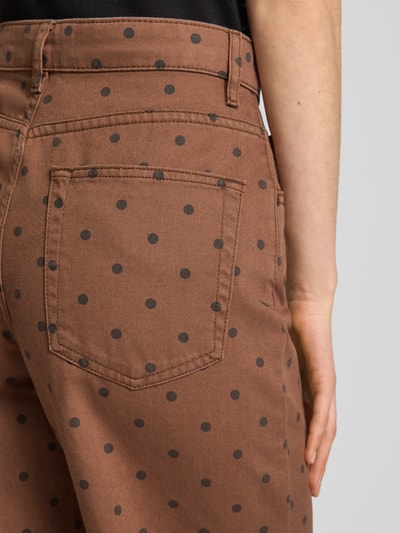 Frauenmodel trägt Wide Fit Jeans im 5-Pocket-Design von Mango in Braun mit schwarzen Punkten, reine Baumwolle, Detailaufnahme Rückansicht.