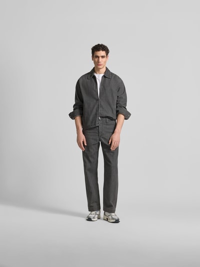 Männermodel trägt Regular Fit Jeansjacke aus Baumwoll-Mix von ANNARR, grauer Denim, Zweiwege-Reißverschluss, Umlegekragen, Ganzkörperansicht von vorne. Rückenlänge bei Größe M 70 cm, Schulterbreite 54 cm, Ärmellänge 65 cm.