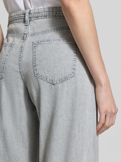 Frauenmodel trägt Regular Fit Wide Leg Jeans aus reiner Baumwolle Modell 'AISA' von Vero Moda, hellgrauer Denim mit Twill-Struktur, Nahaufnahme Rückansicht.