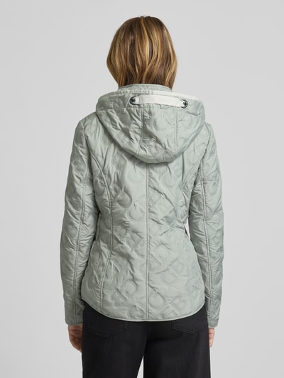 Vrouwenmodel draagt Jacke mit Stehkragen und Reißverschlusstaschen van Gil Bret in lichtgroen, getailleerde fit, katoenen stof, met capuchon en ritszakken, weerbeschermend, ruglengte maat 36: 61 cm, schouderbreedte: 37 cm, borstwijdte: 50 cm, mouwlengte: 64 cm. Volledig aanzicht achteraan.