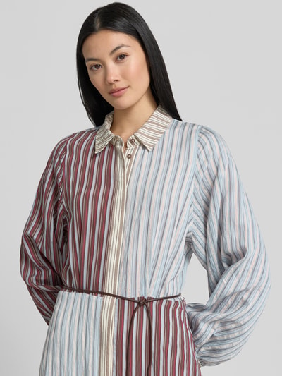 Modelka nosi sukienkę koszulową 'Hemdblusenkleid aus Lyocell-Mix mit Bindegürtel' od Jake*s Casual, wzór na całej powierzchni, mieszanka lyocellu z dodatkiem wiskozy, linia a, sukienka midi, zakryta listwa guzikowa, wiązany pasek, długość tyłu w rozmiarze 36: 124 cm, szerokość w rozmiarze 36: 41 cm, długość rękawów: 57 cm, kolorowe pionowe paski, lekko błyszcząca faktura, widok z przodu, zbliżenie na górną część ciała.