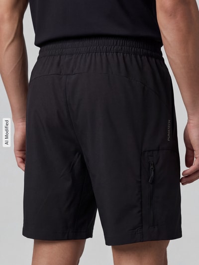 Männermodel trägt Regular Fit Sportshorts mit Label-Print von PUMA, Schwarz mit glatter Struktur, Herren Sweatshorts, Ganzkörperansicht Rückansicht.