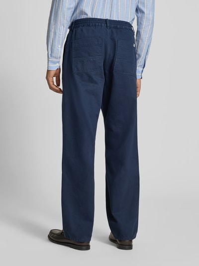 Männermodel trägt Jeans mit elastischem Bund von Forét in Dunkelblau, Reine Baumwolle, Straight, Gesäßtaschen, Ganzkörperansicht Rückansicht.