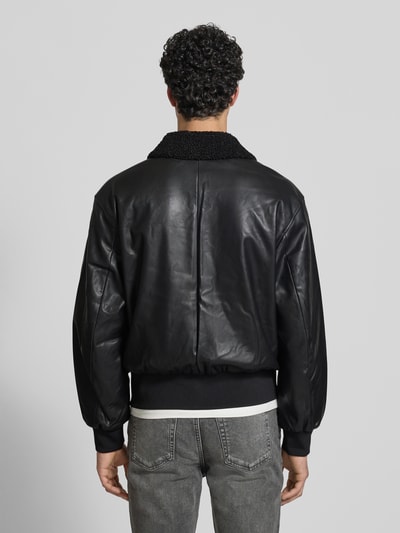 Männermodel trägt Regular Fit Jacke in Leder-Optik mit Umlegekragen von Calvin Klein Jeans, Schwarz, elastische Abschlüsse, Ganzkörperansicht Rückansicht