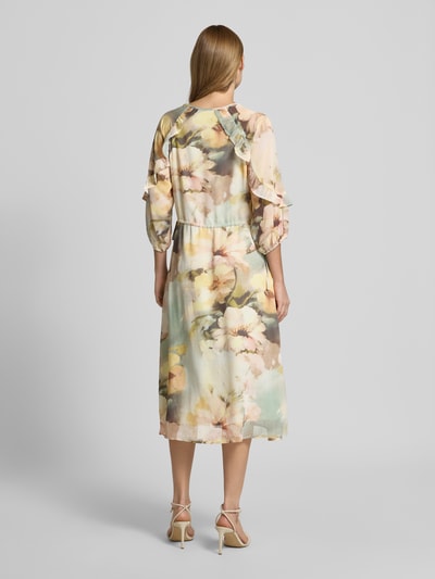 Frauenmodel trägt Midikleid mit V-Ausschnitt von Soyaconcept, florale Farben, Leicht taillierte Passform, 3/4-Arm, Rüschenbesatz, Midilänge, Rückenlänge Größe S 128 cm, Brustweite 40 cm, Ärmellänge 42 cm, Ganzkörperansicht Rückansicht.
