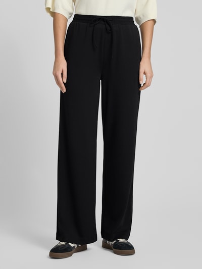 Frauenmodel trägt schwarze Stoffhose mit elastischem Bund und Tunnelzug, Modell 'NANNI' von FREE/QUENT, lockerer Schnitt, Ganzkörperansicht von vorne.
