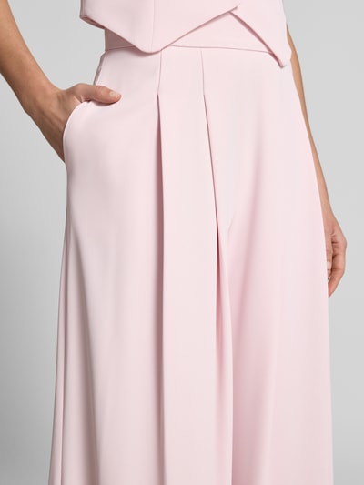 Frauenmodel trägt Stoffhose mit französischen Eingrifftaschen von Rinascimento in Hellrosa, glatte Textur, Wide Leg Fit, Nahaufnahme Oberkörper.