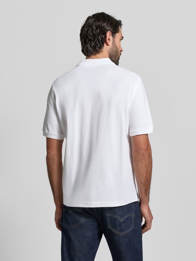 Męski model ma na sobie Slim Fit Poloshirt mit Logo-Stitching od Gant, biała bawełna, krój slim fit, polo kołnierz, krótkie rękawy, całkowita długość tyłu w rozmiarze M: 70 cm, widok całej sylwetki od tyłu.