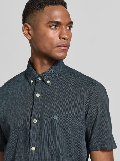 Männermodel trägt Regular Fit Freizeithemd mit Button-Down-Kragen von camel active, reine Baumwolle, feine Streifen, Nahaufnahme Oberkörper.
