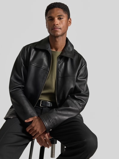 Męski model nosi Regular Fit kurtka skórzana z czarnej skóry owczej model 'JOBAN1' od BOSS Orange, neutralne tło, zdjęcie całej sylwetki z przodu.