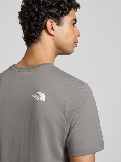 Männermodel trägt T-Shirt mit Label-Print von The North Face in Grau, Baumwoll-Mix, Regular-Fit, Nahaufnahme Oberkörper, Rückenansicht.