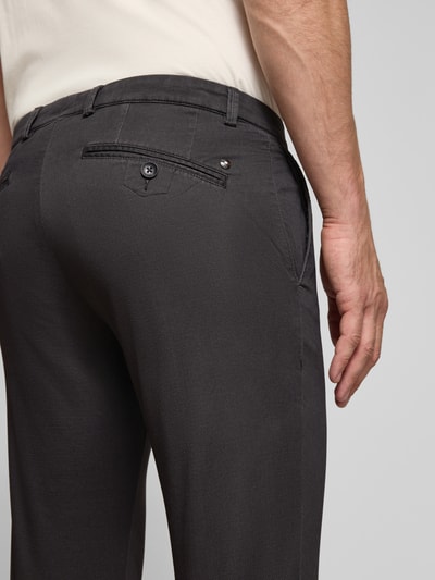 Männermodel trägt Slim Fit Chino aus Baumwoll-Mix von bugatti in Dunkelgrau, Gesäßtaschen, Nahaufnahme Rückansicht.