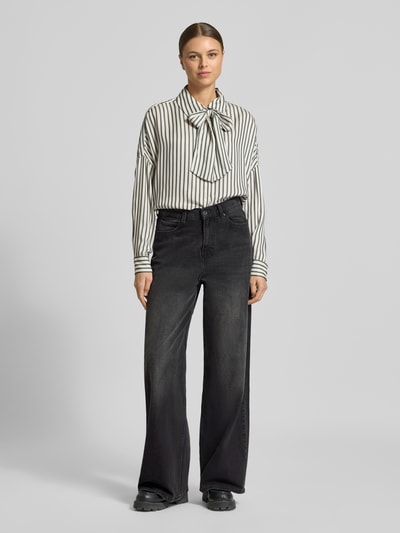 Frauenmodel trägt Wide Fit Jeans im 5-Pocket-Design Modell 'Luise' von Mustang, schwarze Denim-Struktur, elastischer Baumwoll-Mix, Ganzkörperansicht von vorne.