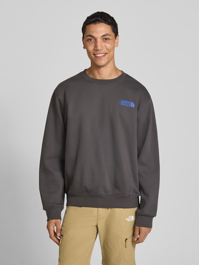 Männermodel trägt Relaxed Fit Sweatshirt aus katoenmix von The North Face, heren sweatshirt met logoprint, ronde hals, elastische boordjes, ruglengte maat M 68 cm, mouwlengte maat M 68 cm, Ganzkörperansicht von vorne