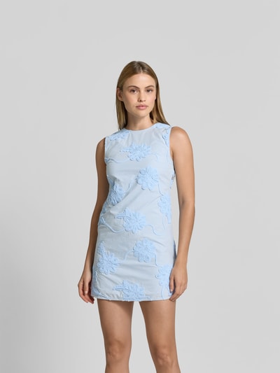 Frauenmodel trägt Minikleid mit Stretch-Anteil von ROTATE, hellblau, Reine Baumwolle, taillierte Passform, Rundhalsausschnitt, Florale-Stickereien, Ärmelloses-Design, Nahaufnahme Oberkörper.