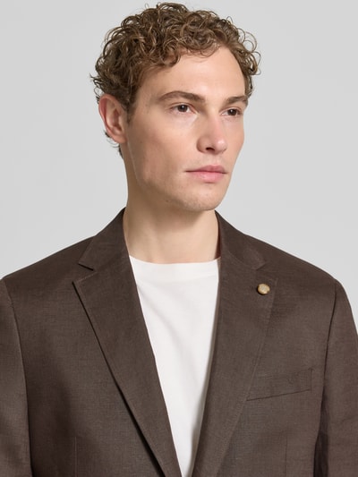 Männermodel trägt Regular Fit Sakko aus reinen Leinen mit Reverskragen von Christian Berg Men, Braunton, strukturierte Oberfläche, Nahaufnahme Oberkörper, Brusttasche, AufgesetzteTaschen, 2-Knopfleiste, Rückenlänge 75 cm, Schulterbreite 47 cm, Ärmellänge 63 cm, Größe 50.